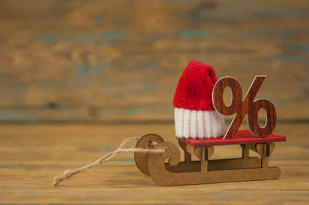 sledge with a big percent sign on wood background with copy space. Christmas big saleの写真素材