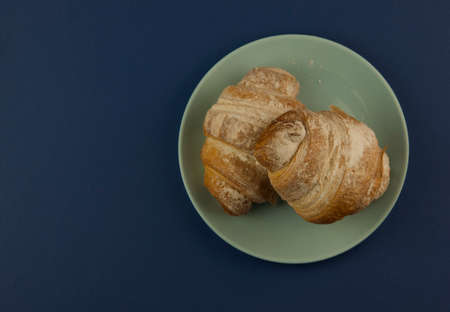 croissant on blue background fresh bakery sweet dessert bun snack healthy meal copy space for text food background rustic imageの写真素材