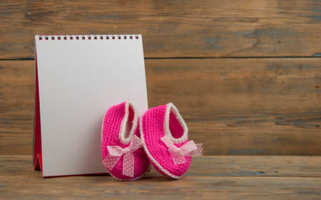 Selected due date in the calendar and detail of baby shoesの写真素材