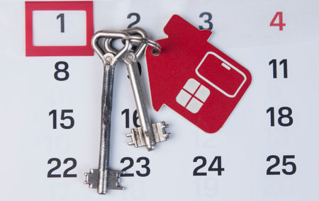 House key with keychain pinned to the calendar. Real estate purchase , mortgage loan repayment time, housing tax payment deadline, conceptの写真素材