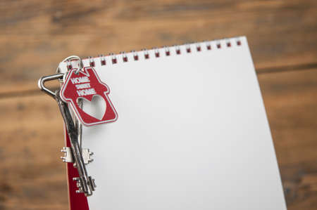 House key with keychain pinned to the calendar. Real estate purchase , mortgage loan repayment time, housing tax payment deadline, conceptの写真素材