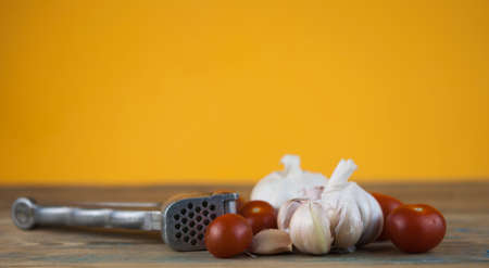 on wooden table cherry tomatoes with head garlicの写真素材