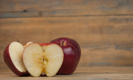 A composition of red apples, cut and whole, on a wood background. natural fruits. The half of apple....
