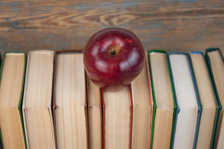 stack of books with red apple on the wood table with copy space. back to schoolの写真素材