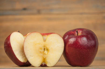 A composition of red apples, cut and whole, on a wood background. natural fruits. The half of apple. Space for your text.の写真素材