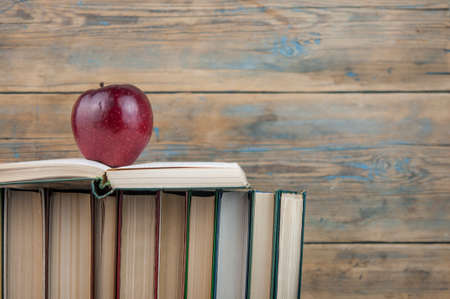 stack of books with red apple on the wood table with copy space. back to schoolの写真素材