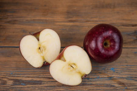 A composition of red apples, cut and whole, on a wood background. natural fruits. The half of apple. Space for your text.の写真素材