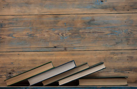 Many stacked books on wooden background. Back to school with copy space.の写真素材