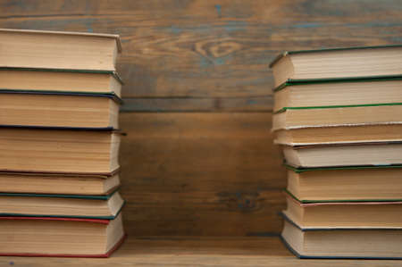 Many stacked books on wooden background. Back to school with copy space.の写真素材