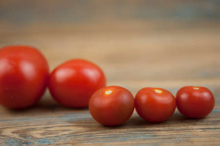 Red ripe tomatoes on rustic weathered wooden table. Harvest of Organic vegetables.の写真素材