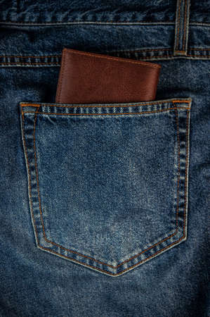 brown leather wallet the back pocket of blue shabby jeans hipster modern life style layout for inserting textの写真素材
