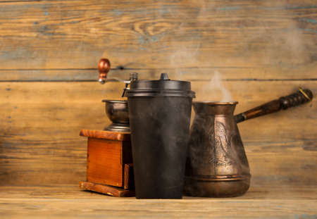 cup of coffee, coffee beans, turk, coffee grinder on a wooden backgroundの写真素材