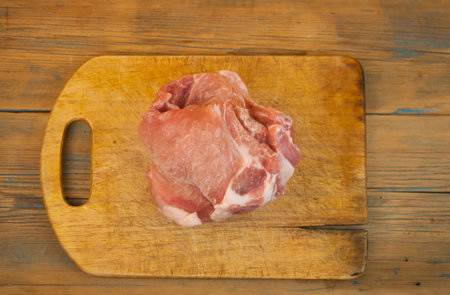 Pieces of raw pork on the table. On a dark backgroundの写真素材