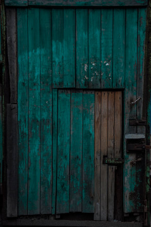 Old dark wooden rustic look barn doors. Metal hinges, and lock holders placed on the rough texture doors are very rusty.の写真素材