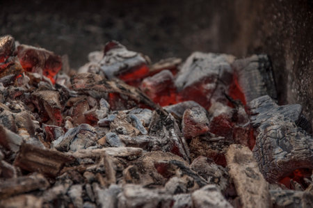 Burning coals in the dark, smoldering coal. Bright red sparks of fire. background.の写真素材