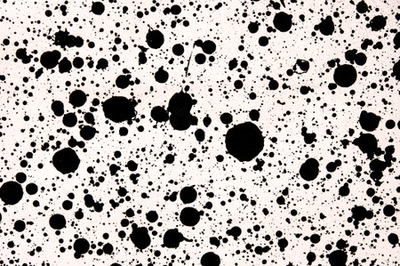 Splattered pf black ink drops on white backgroundの写真素材