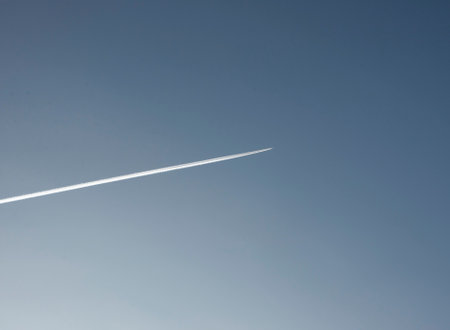 trace of an airplane against blue skyの写真素材