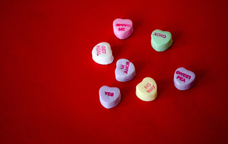  Candy hearts with fun sayings on a red background