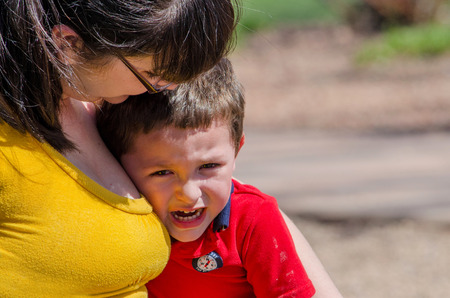 A mom consoles  her crying toddler son