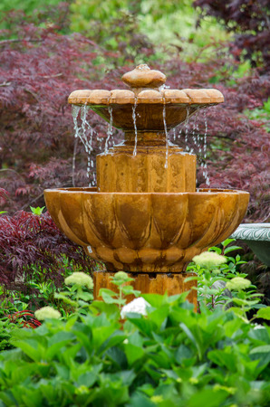 A fountain in a garden, creates a tranquil peaceful spot to sit and relaxの写真素材