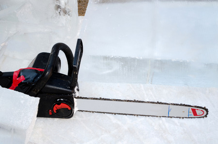 A chain saw is used to carve art out of cold blocks of ice at a michigan ice festivalの写真素材
