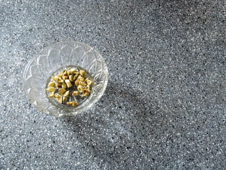 Sliced garlic in a plate. Spices for cooking on a gray backgroundの写真素材
