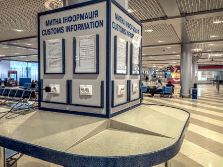 Ukraine, Boryspil - January 16, 2020: A stand with customs information and sockets for charging gadgets in terminal F of the Boryspil International Airport. Large airport lounge with tourist servicesのeditorial素材