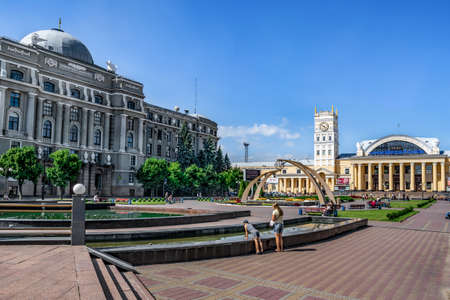 Kharkiv, Ukraine - July 20, 2020: Pryvokzalnyi Maidan in Kharkov on a sunny summer day. The buildings of the Office of the Southern Railway and the railway station on the square with bright flowerbedsのeditorial素材