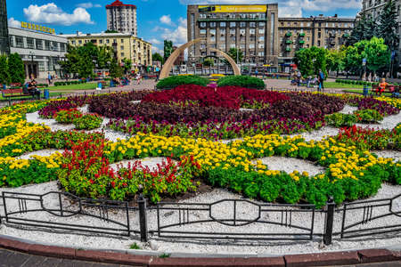 Kharkiv, Ukraine - July 20, 2020: Bright multi-colored flowerbed with summer flowers on Pryvokzalna Square in Kharkov. Colorful cityscape with landscaping on the background of multi-storey buildingsのeditorial素材