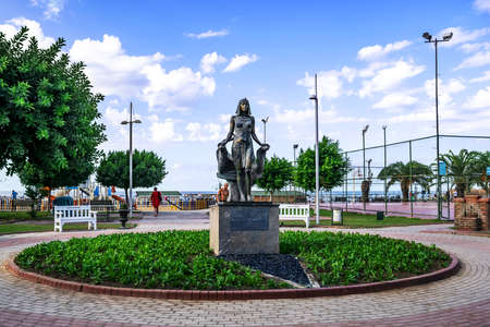 Turkey, Alanya - October 22, 2020: Bronze Cleopatra statue in the middle of a flower bed in a park on the embankment of Mediterranean sea in Alanya. Female Egyptian sculpture in a tropical landscapeのeditorial素材