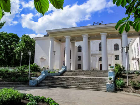 Central entrance to the Palats Kultury in Sumy (Ukraine). Cultural center building with white walls and columns on a sunny summer dayの写真素材