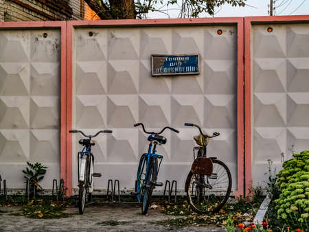 Parking for bicycles at the railway station in Buryn (Sumy region).  Old vintage bikes are parked against the wall at Putyvl Train Station, outdoorsの写真素材