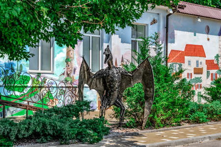 Kherson, Ukraine - July 22, 2020: Metal sculpture of a prehistoric lizard on Kanatna street in Kherson. A park composition with a decorative pterodactyl against the background of a painted buildingのeditorial素材
