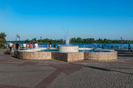 Kherson, Ukraine - July 22, 2020: The fountain on the waterfront in Kherson. People walk on the promenade of the Dnieper river on a sunny summer dayのeditorial素材