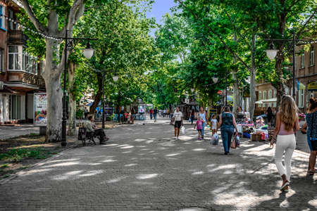 Kherson, Ukraine - July 22, 2020: Pedestrian historical Suvorova Street in Kherson. People walk along the old alley with green trees on a sunny summer dayのeditorial素材