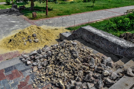 A pile of rubble and sand on the stairs in the Kazka park in Sumy (Ukraine). Building materials for repair of the sidewalk and steps on the street on a sunny summer dayの写真素材