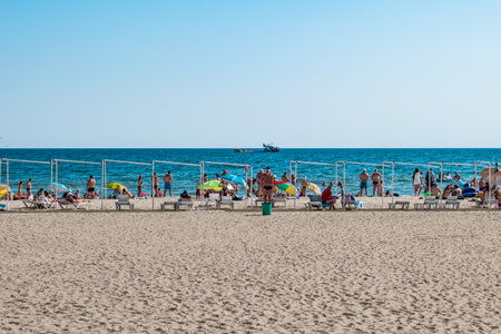 Zaliznyi Port, Ukraine - July 23, 2020: Beach coastline in the resort village of Zalizny Port. People are resting on white sand against a background of blue waterのeditorial素材