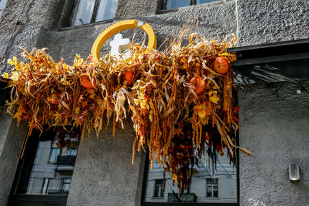 Kharkiv, Ukraine - October 20, 2020: Commercial enterprise logo decorated with autumn leaves and pumpkins for Halloween in Kharkiv. Festive decoration of the facade of an office buildingのeditorial素材
