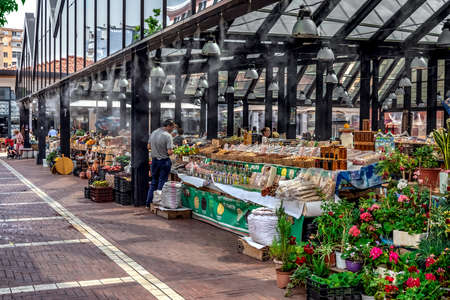 Tirana, Albania - June 21, 2021: Air humidification at Pazari i Ri street market in Tirana. Buyers and sellers in the background of stalls with nuts, honey and other foodのeditorial素材