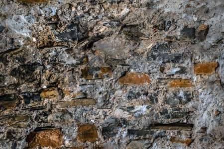 Real stone texture of cemented cobblestones and wooden planks. Grey-brown grunge rough pattern