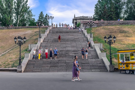 Mykolaiv, Ukraine - July 25, 2020: Many people go down the high granite stairs on Bulvar Flotskiy...