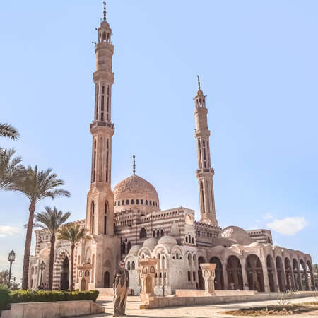 A young adult girl wearing a hijab and an Islamic dress stands in front of the Al Mustafa Mosque in...