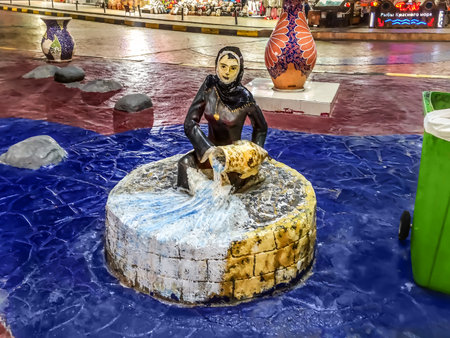 Sharm El Sheikh, Egypt - January 19, 2020: Statue of an Egyptian woman holding a jug of water in the town square in Naama Bay area in Sharm El Sheikh at night. Evening cityscape of an Egyptian resortのeditorial素材