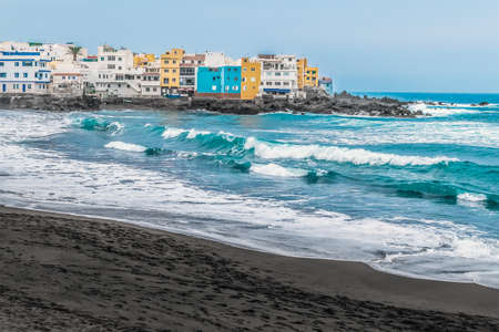 Big waves with white crests on the black sand beach of Playa Maria Jimenez in Puerto de la Cruz, Spain. Seascape of the coast of the Atlantic Ocean in the Canary Islandsの写真素材