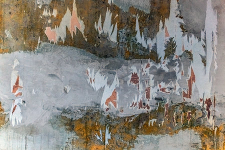Texture of an old dilapidated wall with torn wallpaper. Plastered surface with layers of paint,...