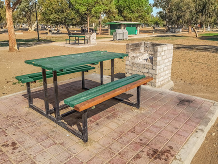 Barbecue area at Lara Beach Park in Antalya, Turkey. Wooden table, benches and a brick stove in a city garden in a Turkish resort townの写真素材