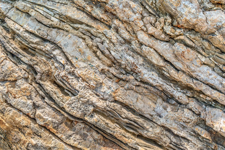 Texture of layered mineral formations on a rock in Budva, Montenegro. Geometric abstract diagonal...