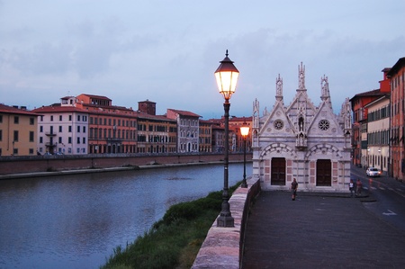 church on the river shore, pisa, italyの写真素材
