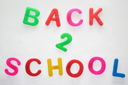 Back 2 school phrase set in plastic magnetic letters over metallic backgroundの写真素材