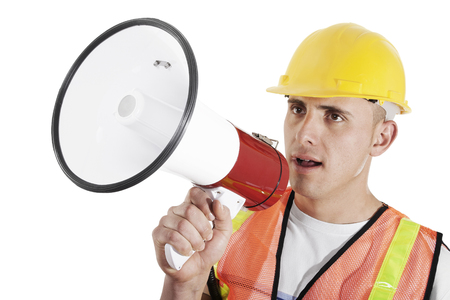 Construction foreman giving orders on bullhorn isolated on white backgroundの写真素材